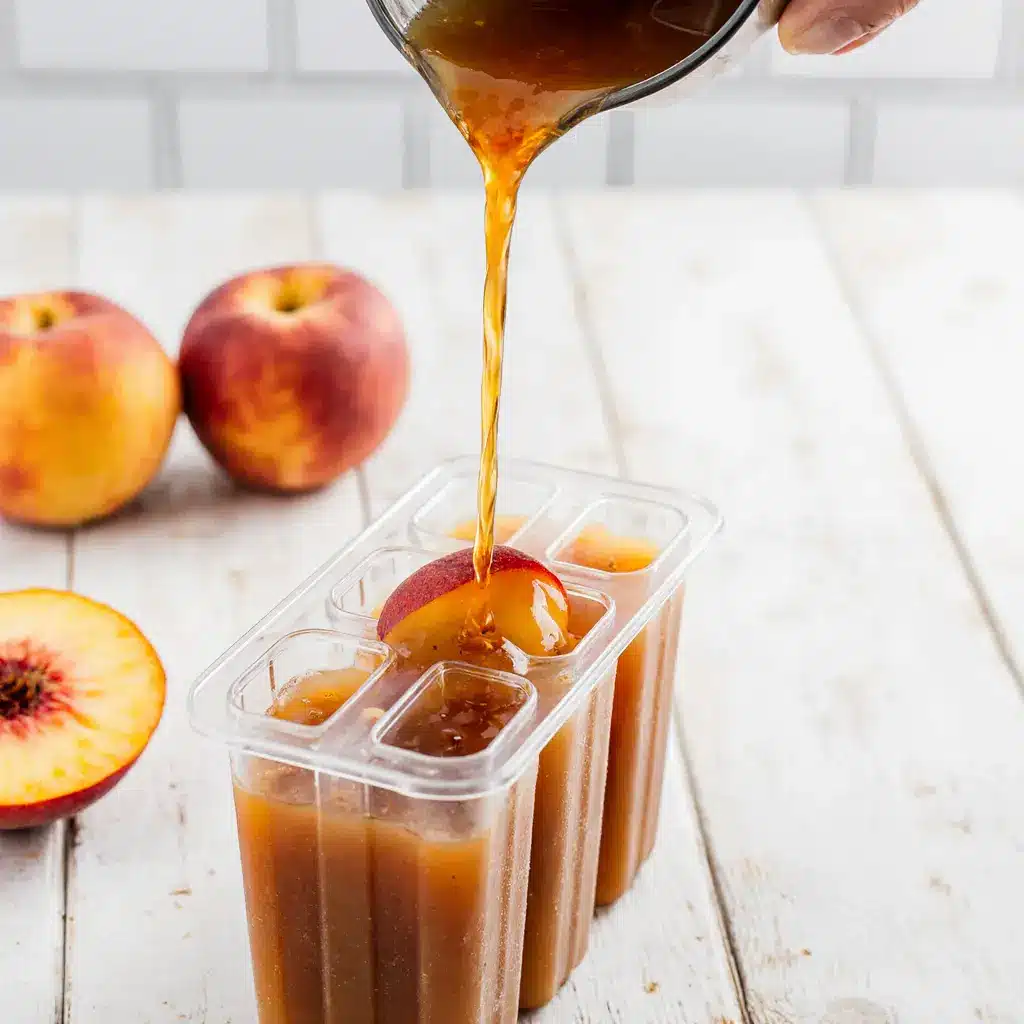 Pouring peach tea mix into molds up close