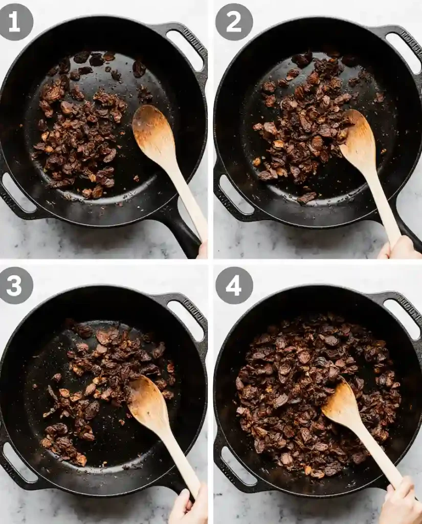 Dried guajillo and ancho chiles being toasted in a skillet for a birria ramen recipe.